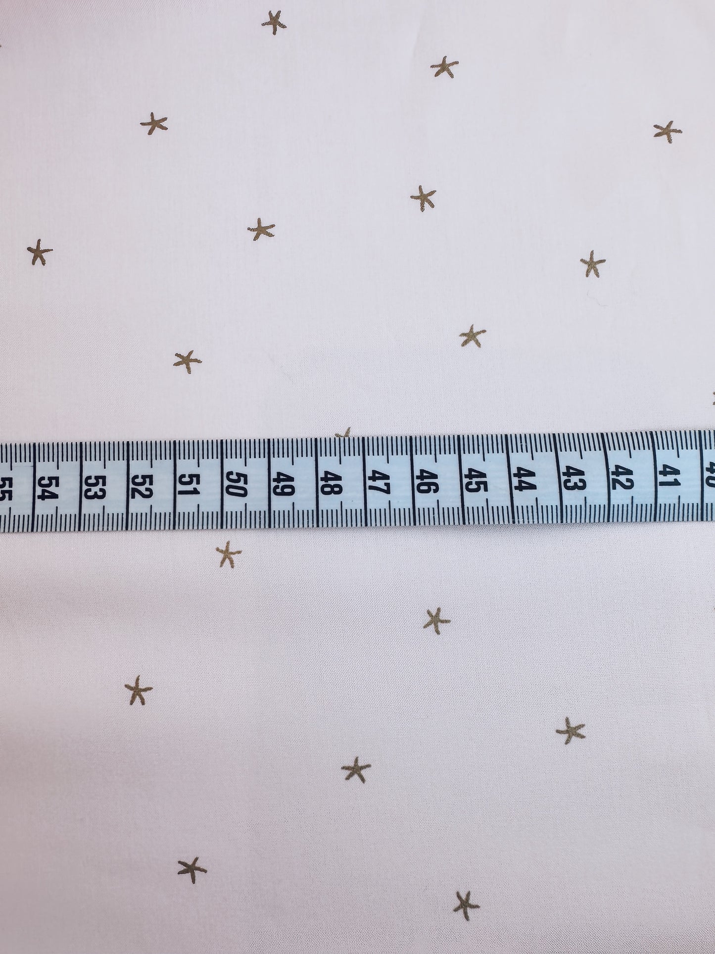 TELA ESTAMPADO ESTRELLAS DORADAS DE 1,5 METROS DE ANCHO. 12 EUROS/ METRO.