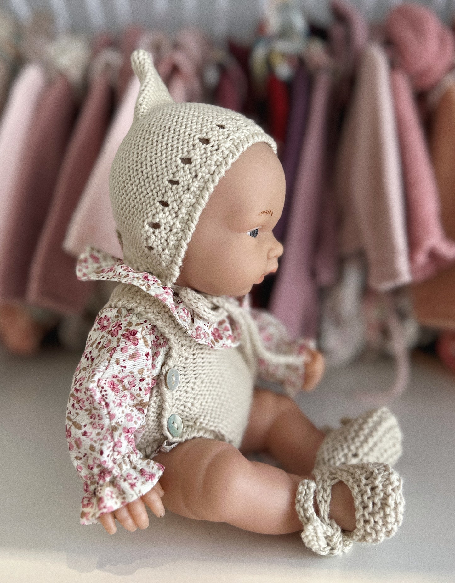 MUÑECA 26CM VESTIDA CON PETO DE PUNTO, CAPOTA DE PUNTO, BLUSA Y PATUCOS