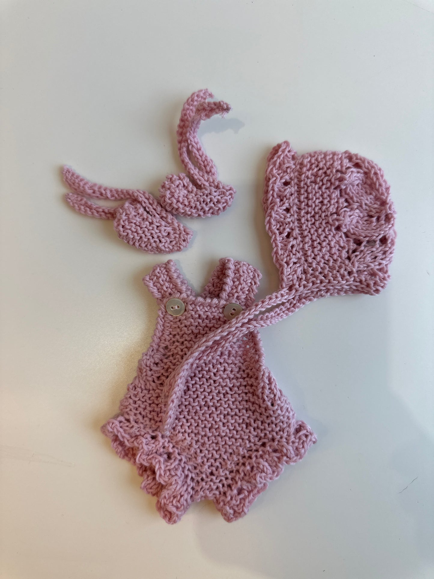 Conjunto peto, capota y patucos de algodón rosa empolvado para muñeco de 21cm