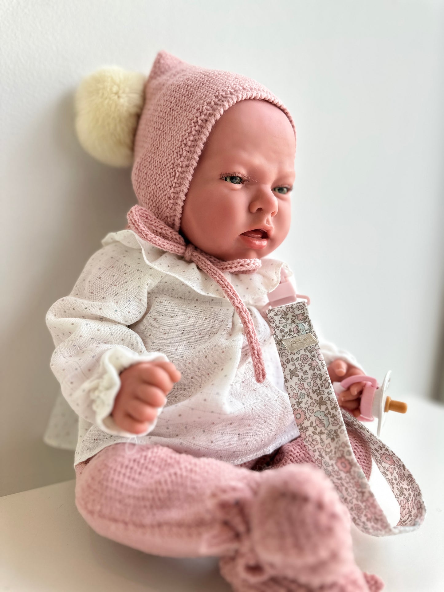 REBORN 40 CENTÍMETROS VESTIDO CON CAPOTA CON POMPON, BLUSA CON CUELLO, POLAINA, PATUCOS Y CHUPETE