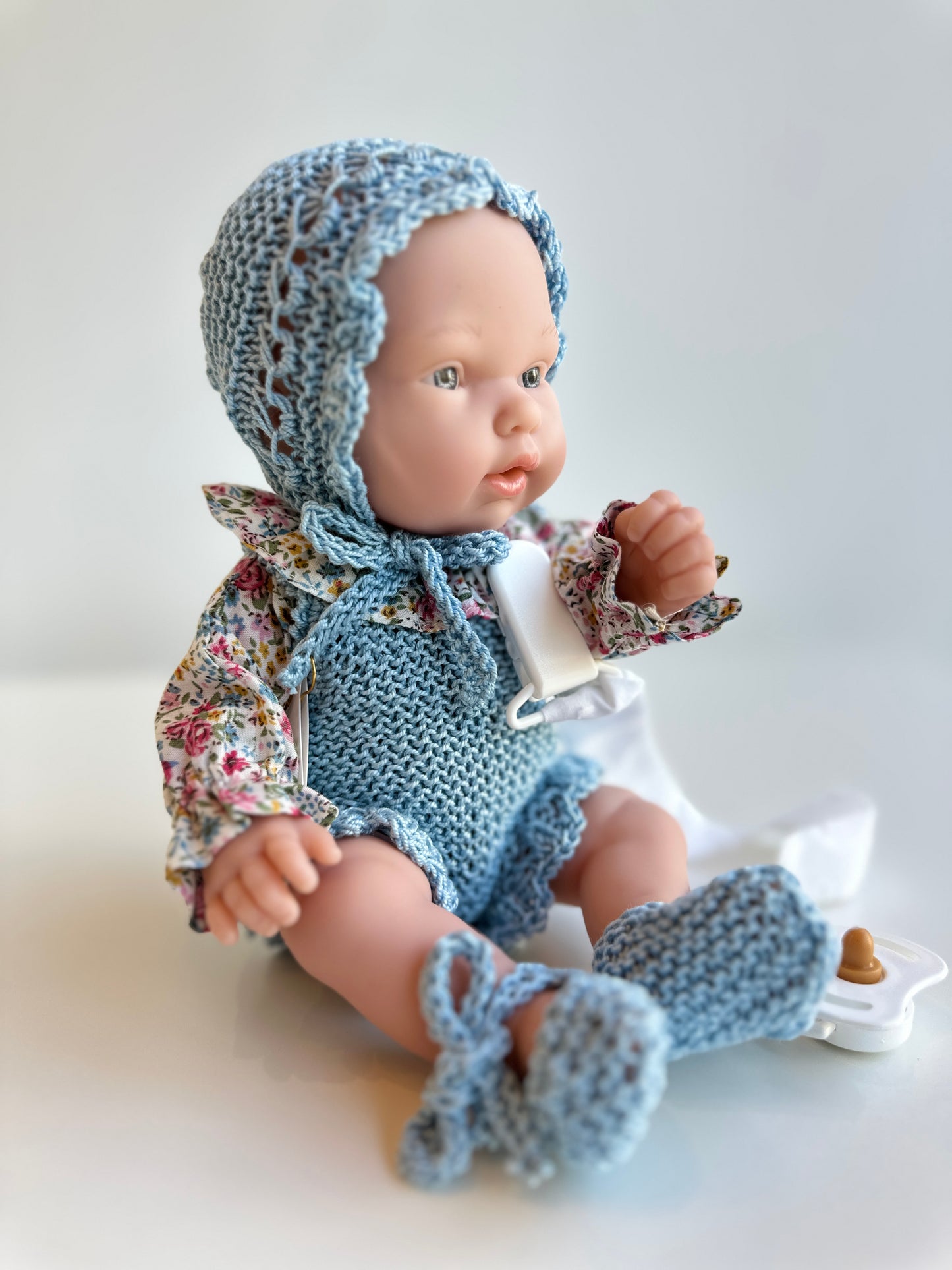 Muñeco 26 centímetros vestido con peto, blusa, capota y patucos