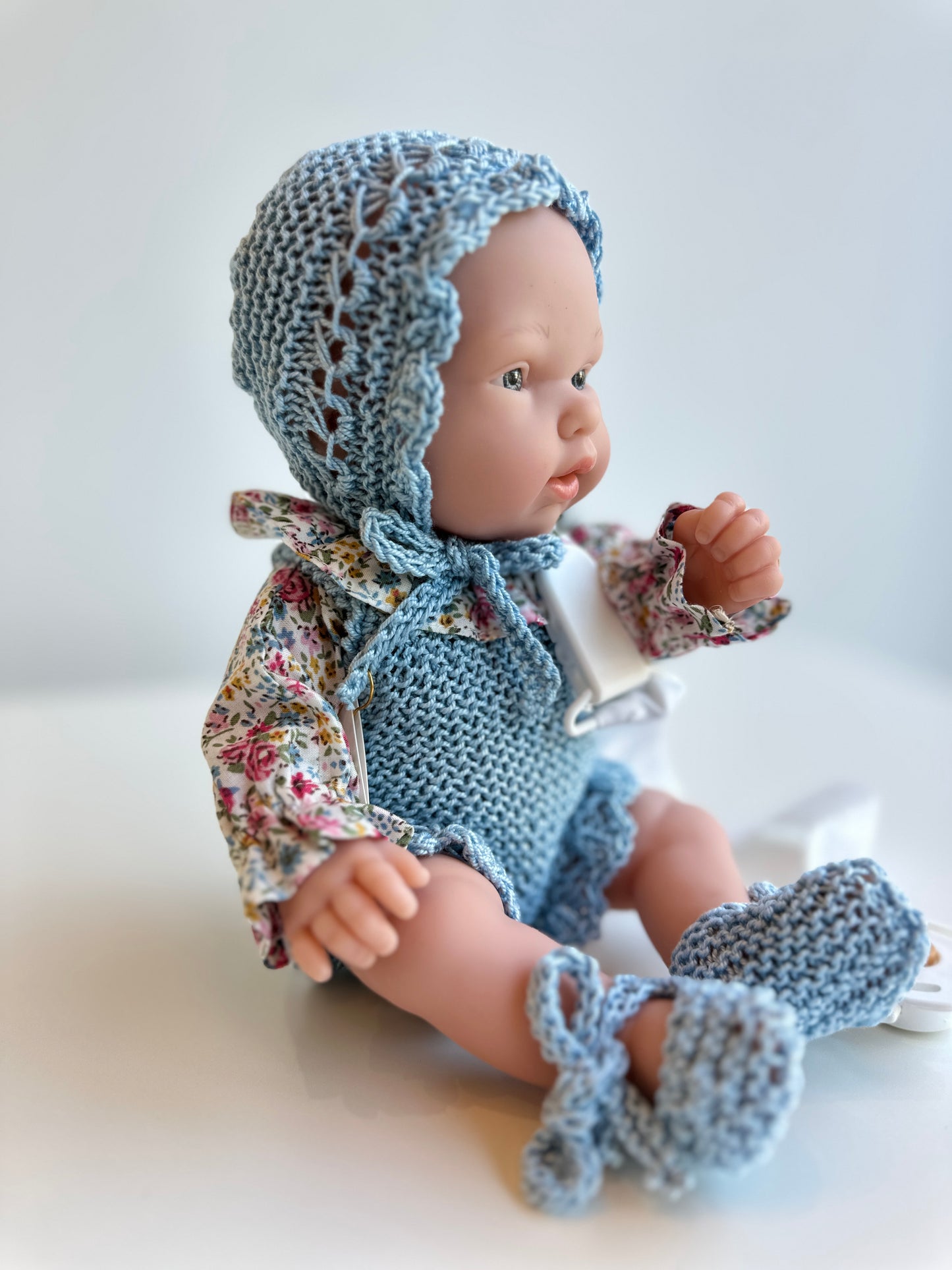 Muñeco 26 centímetros vestido con peto, blusa, capota y patucos